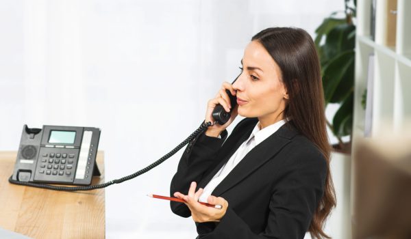 bela-jovem-empresaria-encolher-os-ombros-enquanto-fala-no-telefone