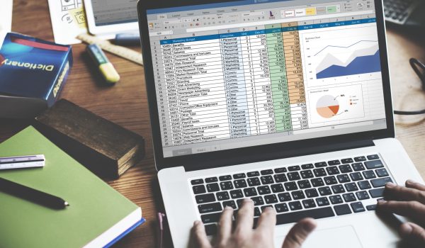 Closeup of hands using computer laptop with screen showing analysis data